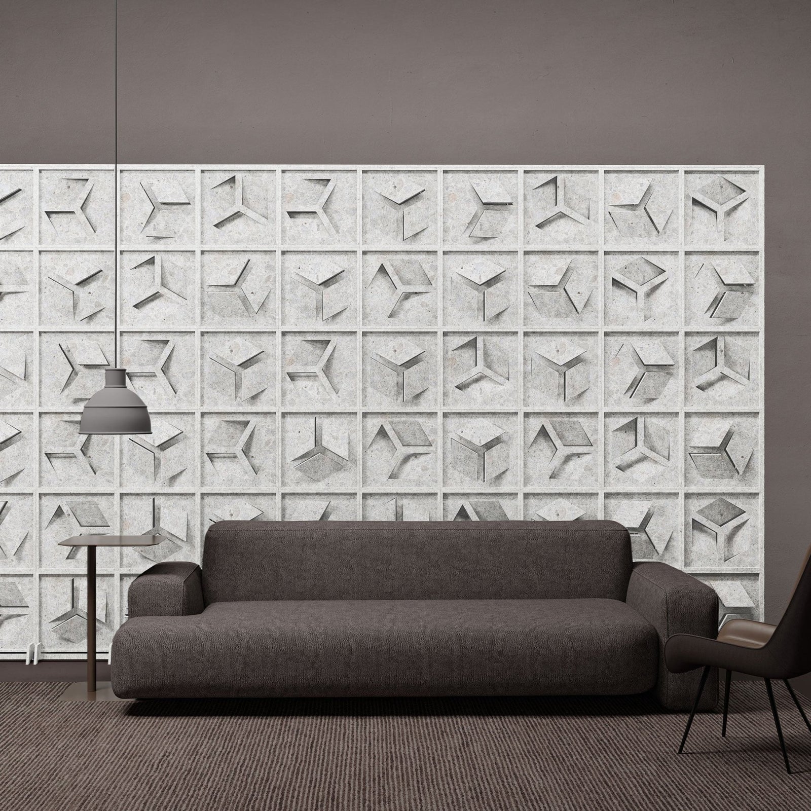 Hex HarmonyBLOKS white geometric acoustic room divider behind a gray sofa by Inhabit.