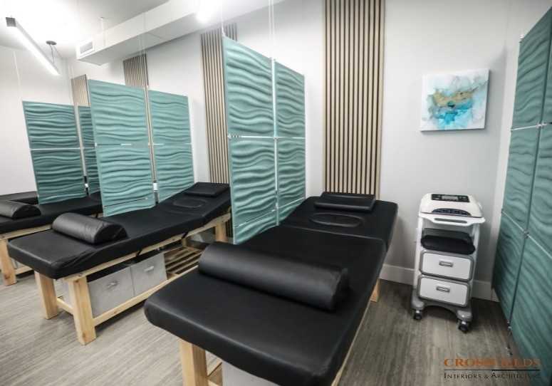 Teal hanging acoustic panels separating treatment tables at Thrive Integrative Health
