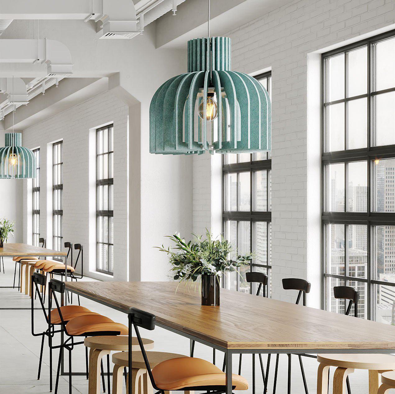 Teal Amien Harmony acoustic pendant lights above a long table in a modern cafe