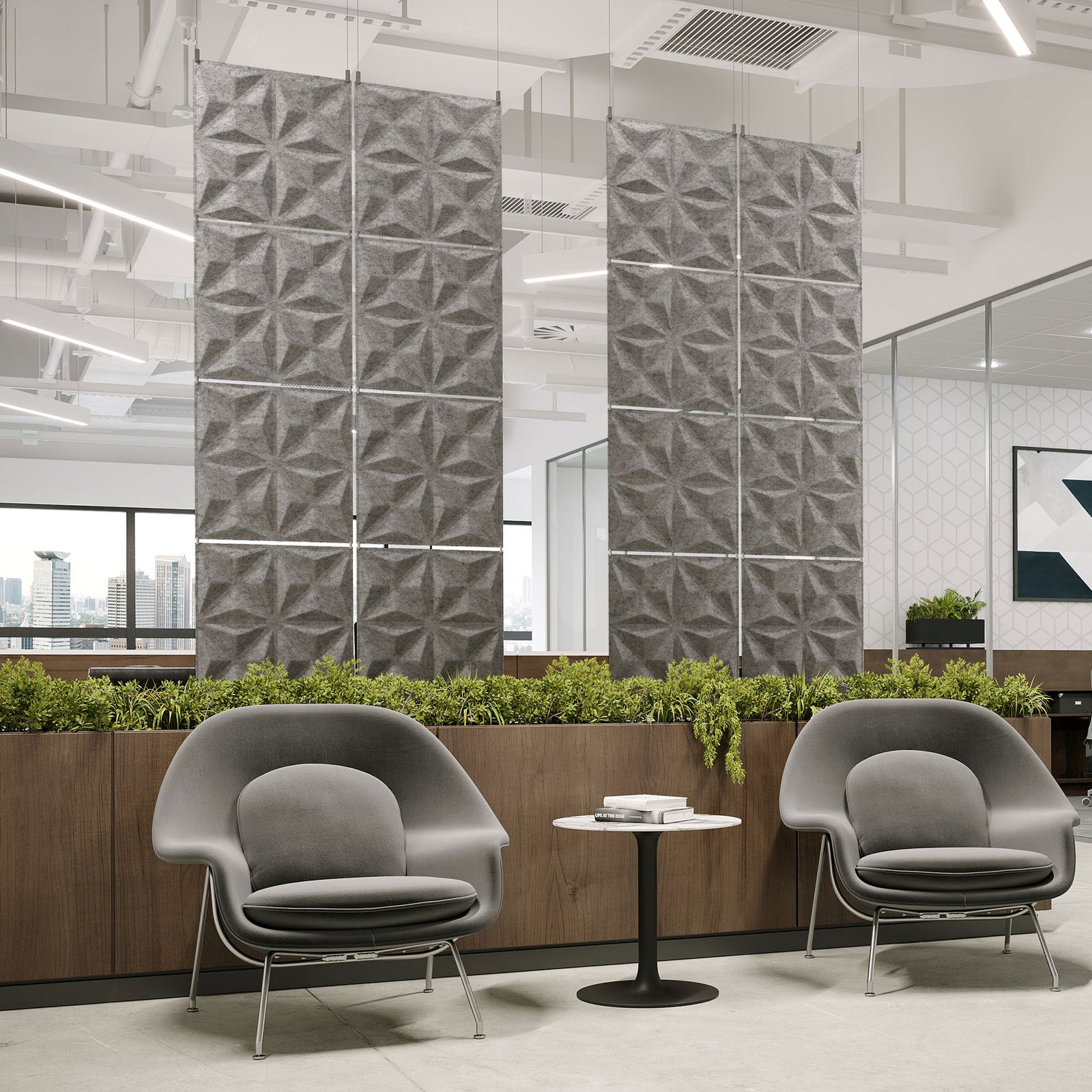 Gray Facet Harmony3D PET felt hanging acoustic panels dividing a modern office seating area by Inhabit
