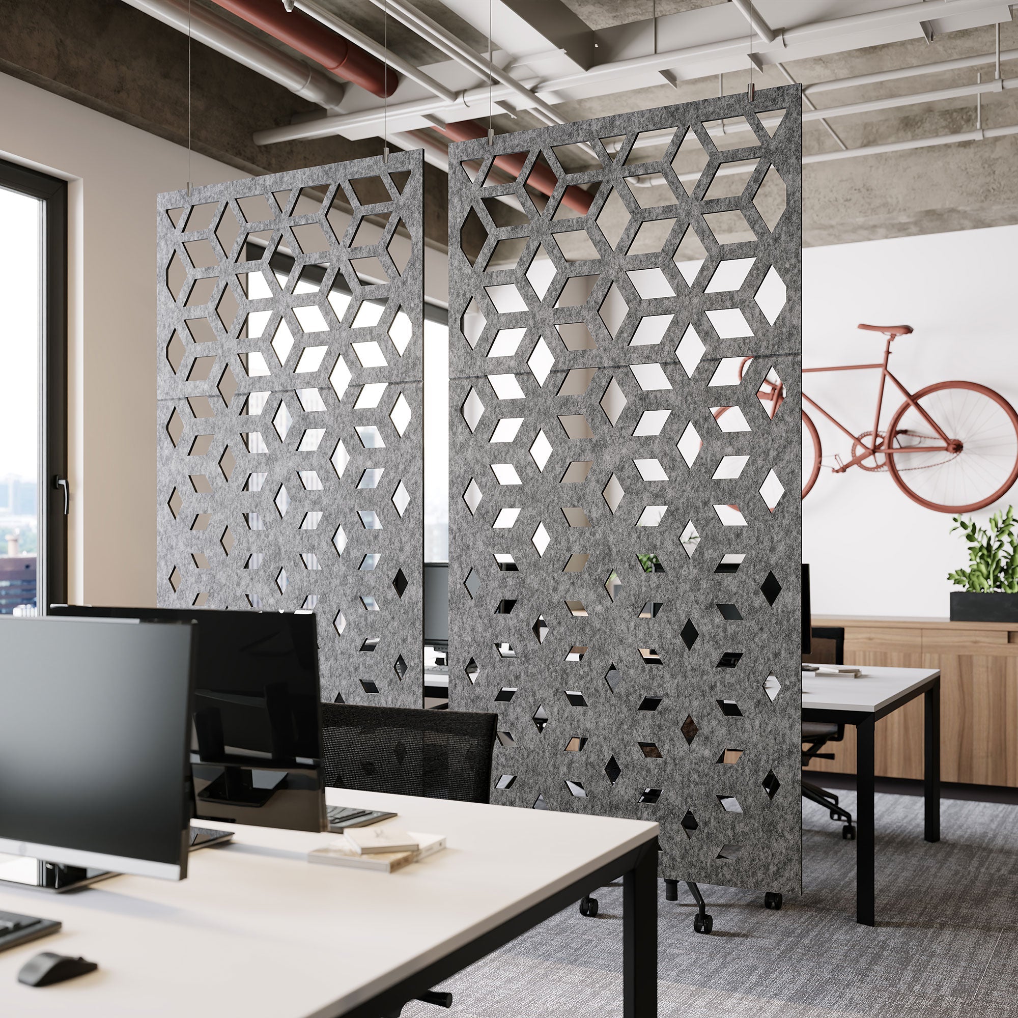 Gray acoustic felt hanging room dividers separating workstations in a modern office